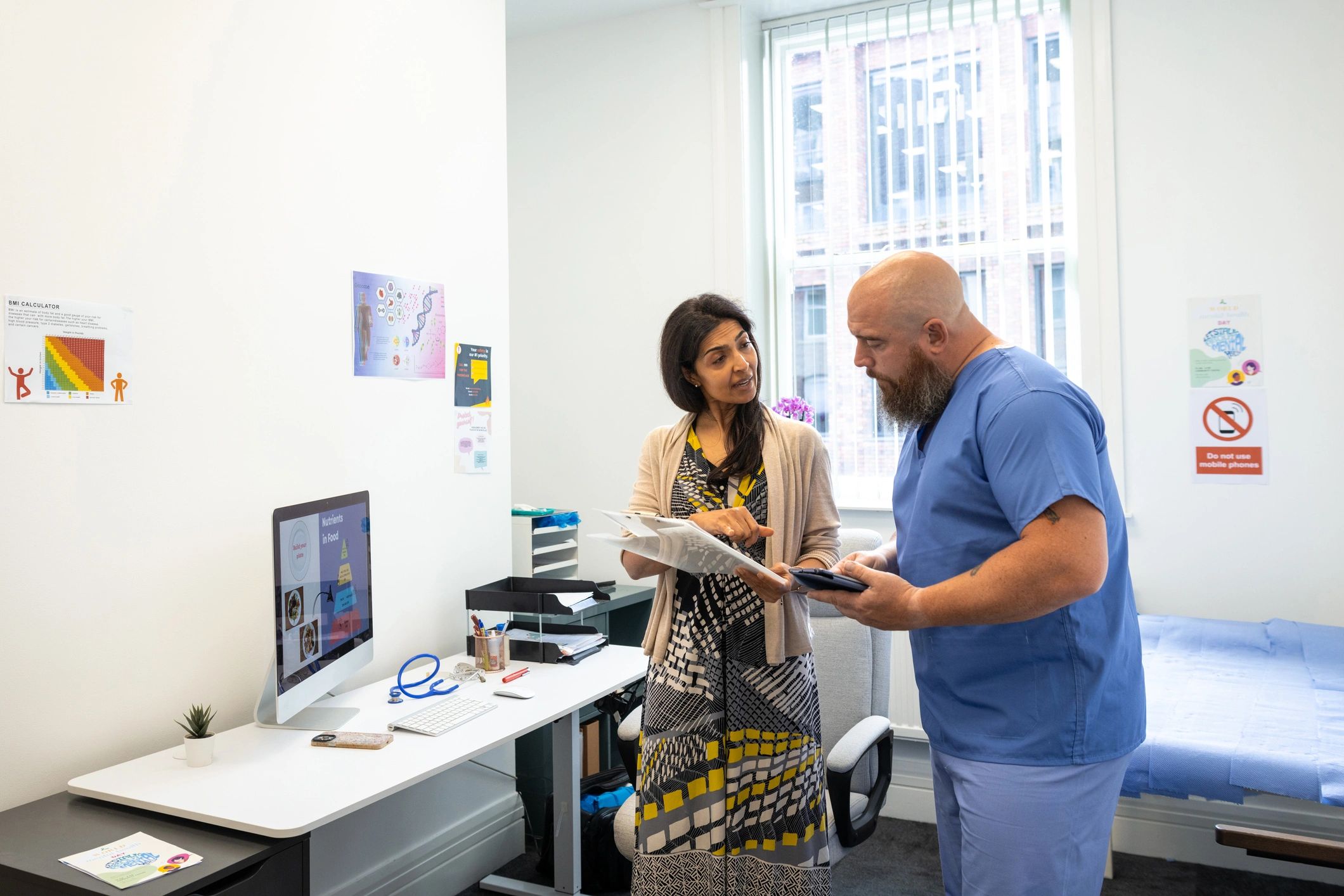 Clinicians reviewing notes together in a consultation setting